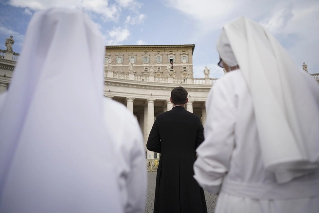 Dos monjas y un padre escuchan la recitación del Angelus del papa Francisco en la Plaza de San Pedro, en el Vaticano, en imagen de antier. Foto Ap 