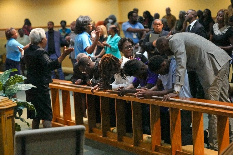 Miembros de la iglesia St. Paul A.M.E. oran con estudiantes de la Universidad Edward Waters, en el centro, que asistieron a un servicio de oración por las víctimas de un tiroteo masivo en Jacksonville, Florida, el 27 de agosto de 2023. Foto Ap