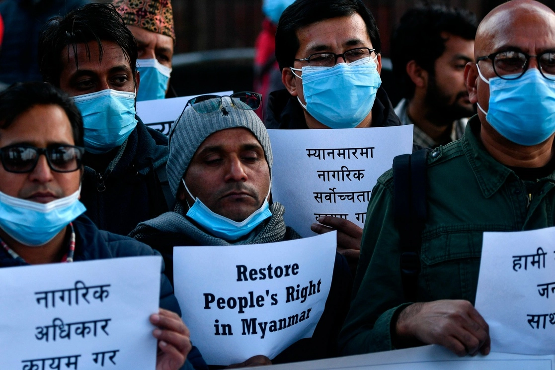 Manifestantes sostienen pancartas durante una protesta en Katmandú después del golpe de Estado en Myanmar, el 1 de febrero de 2021. Foto Afp