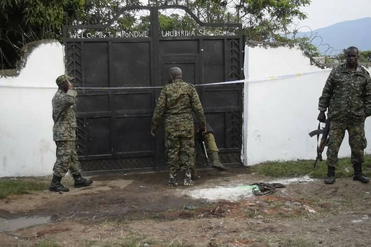 Las fuerzas de seguridad de Uganda se ven de pie en las instalaciones de un ataque en Mpondwe, Uganda,en la escuela secundaria Mpondwe Lhubiriha, el 17 de junio de 2023. Foto Afp 