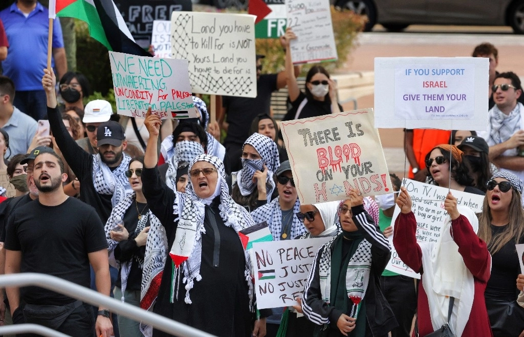 Un partidario pro palestino sostiene carteles durante una manifestación en el ayuntamiento de Orlando, el viernes 20 de octubre de 2023, en Florida.  Foto Ap