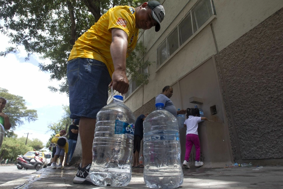 Ante la escasez de agua en la zona metropolitana de Monterrey, ciudadanos acuden a un contenedor comunitario de agua purificada. Foto Cuartoscuro 