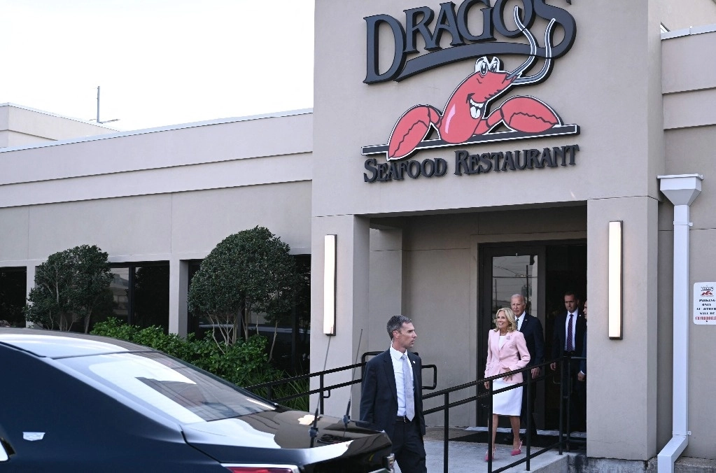 El presidente de Estados Unidos, Joe Biden, y la primera dama, Jill Biden, abandonan el restaurante de mariscos Dragoís, donde cenaron. Foto Afp