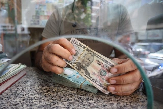 Una persona sujeta un billete de 50 dólares en imagen de archivo. Foto Afp