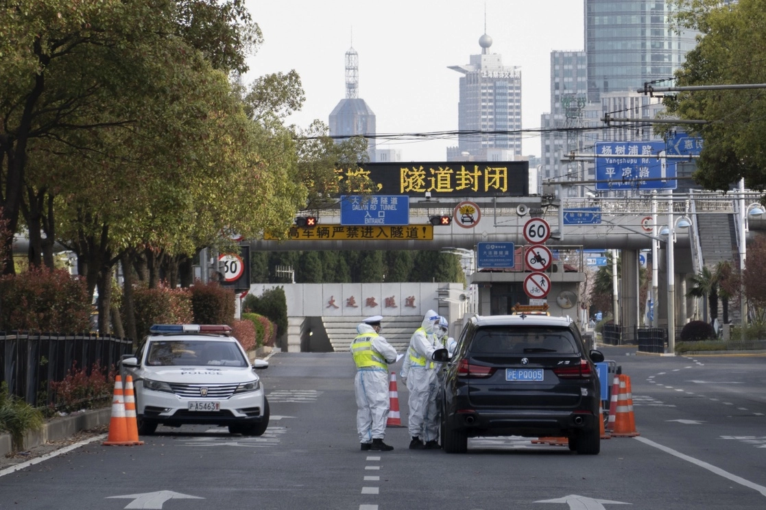 Policías de tránsito con trajes de protección revisan a los conductores, durante el confinamiento en Shanghai, el 28 de marzo de 2022. Foto Ap 