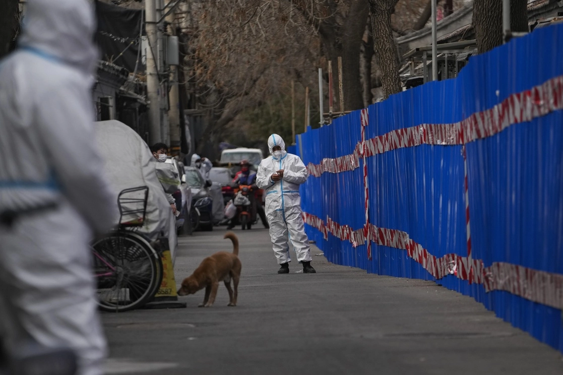Guardias de seguridad vigilan una comunidad cerrada con barricadas para monitorear los estados de salud de sus residentes, luego de que se registraron casos de covid-19 en el área, en Pekín, China, el 22 de marzo de 2021. Foto Ap