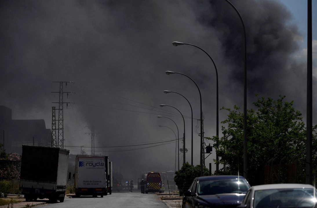 El incendio en un edificio de distribución de productos químicos al sureste de Sevilla, en el sur de España, creó una gran nube negra y obligó a las autoridades a pedir a casi 80 mil residentes que permanecieran en sus casas. Foto  