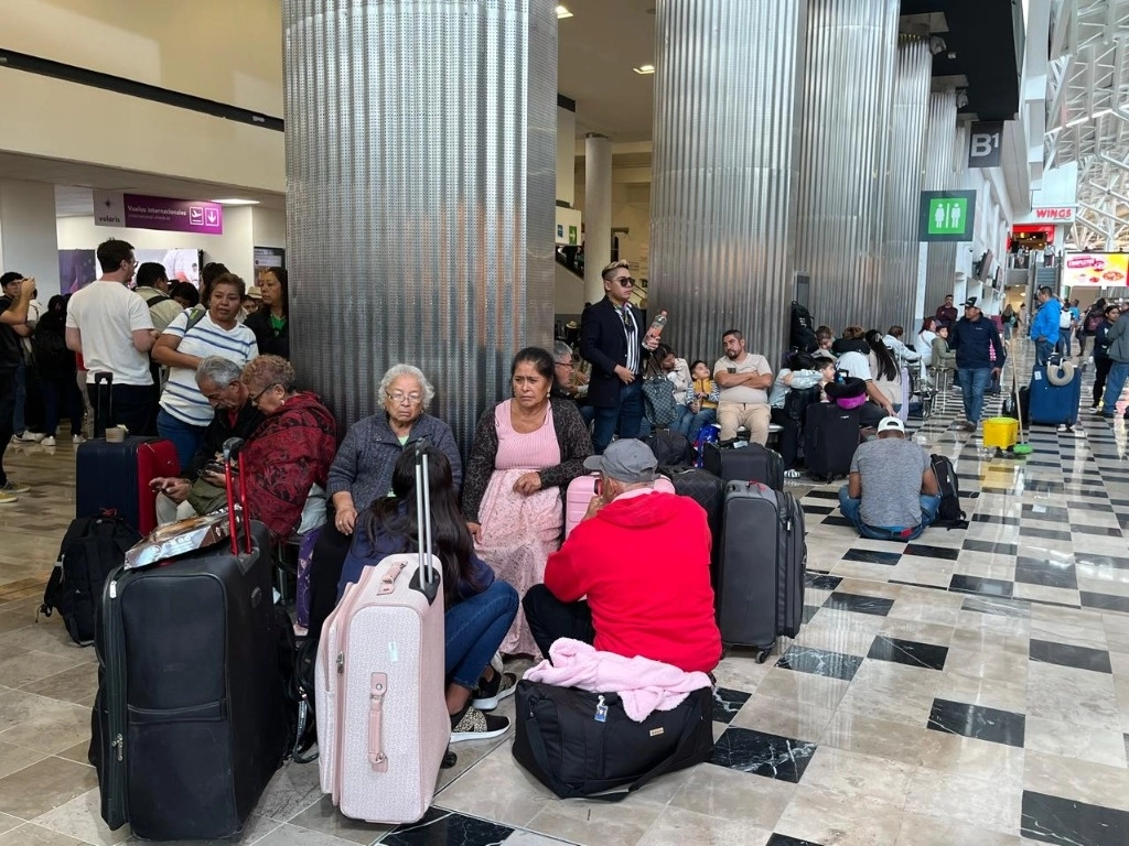 Cientos de viajeros resultaron afectados luego de fallas en sistemas cibernéticos registrados a nivel mundial en varias aerolíneas, en el Aeropuerto Internacional de la Ciudad de México, el 19 de julio de 2024. Los usuarios que perdieron sus vuelos permanecen en la terminal aérea en espera. Foto Alfredo Domínguez


