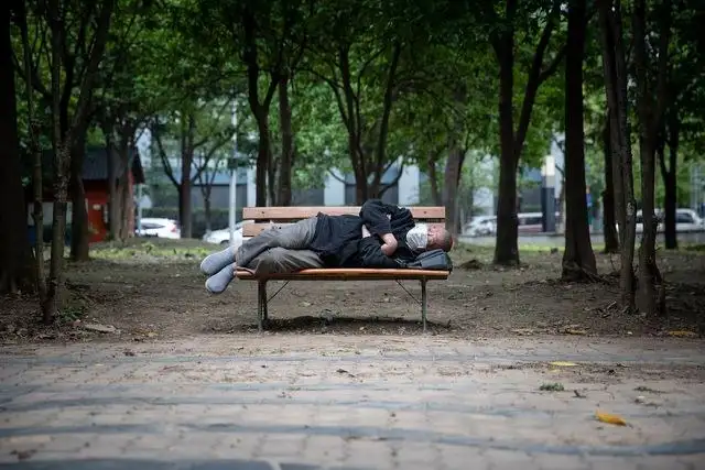 Un hombre descansa en una banca de un parque de la ciudad china de Wuhan. Foto Afp