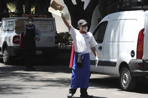 Trabajadores de restaurantes ofrecen comida para llevar en la colonia Roma. Foto María Luisa Severiano