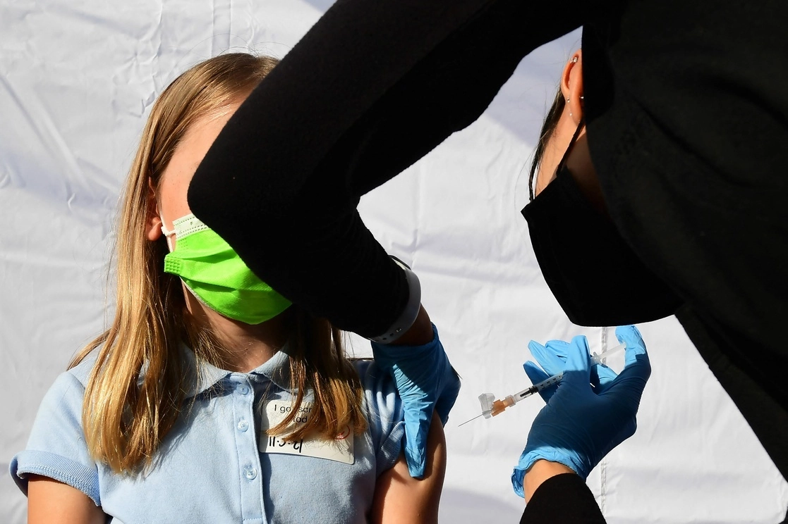 Un trabajador de la salud administra una dosis de la vacuna contra el Covid-19 de Pfizer-BioNTech a una niña de entre 12 y 15 años en Los Ángeles, California. Foto Afp / Archivo