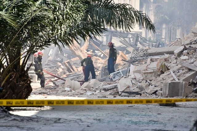 Rescatistas buscan entre los escombros, tras la explosión en el hotel Saratoga, en La Habana. Foto Afp 