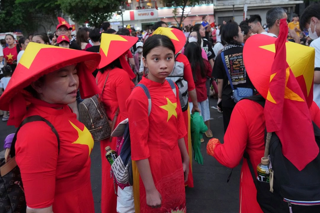 Personas vestidas con los colores de la bandera nacional participan en las celebraciones del 50 aniversario del fin de la guerra de Vietnam con EU, en la ciudad de Ho Chi Minh, el 30 de abril de 2025. Foto 
