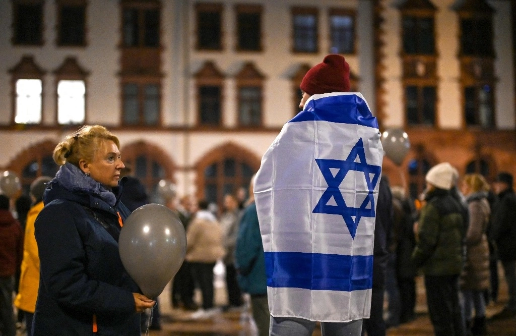 Un hombre con una bandera de Israel participa en una manifestación organizada por partidos alemanes en Dortmund, Alemania occidental para conmemorar el 85th aniversario de la Noche de los Vidrios Rotos (Kristallnacht) que inició el Holocausto. Foto Afp