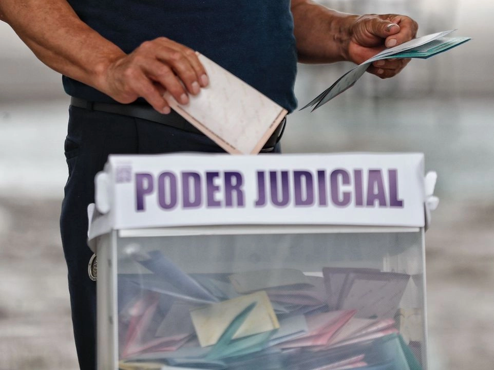 Ciudadano coloca boletas electorales en urna durante elección judicial. Foto 