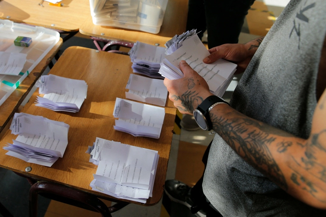 Un funcionario electoral cuenta los votos luego del cierre de las urnas en Chile. Foto Afp