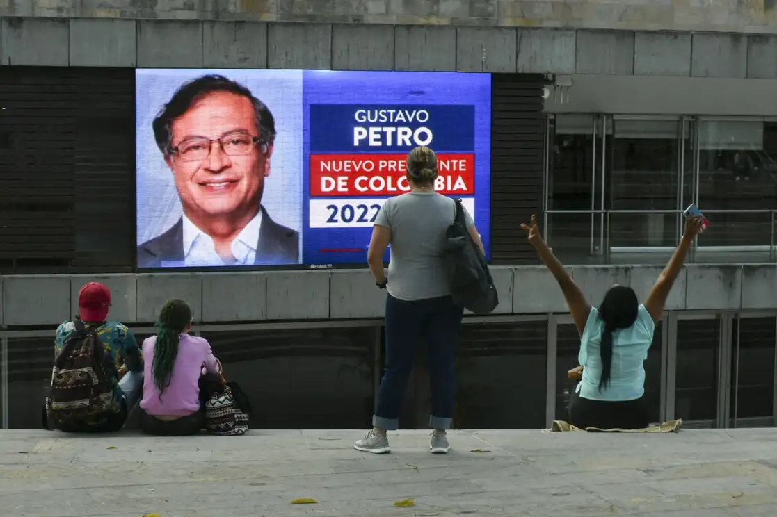 Colombianos miran una pantalla que muestra los resultados preliminares de la segunda vuelta de las elecciones presidenciales, en Medellín, el 19 de junio de 2022. Foto Afp