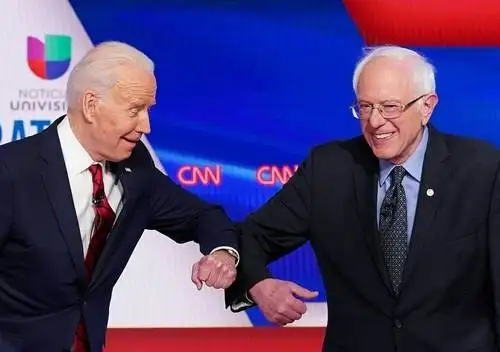 Joe Biden y Bernie Sanders, aspirantes a la candidatura presidencial demócrata, se saludaron conforme a los protocolos por el Covid-19 en el debate del domingo en Washington. Foto Afp