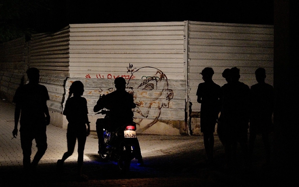 Una silueta de personas se recorta contra la luz de una motocicleta durante el segundo día del apagón nacional en La Habana el 19 de octubre de 2024. El huracán Oscar se acerca a la isla de Cuba de manera inminente, con el riesgo de afectar aún más a la población, que pasa su segunda noche sin electricidad debido a un gran apagón. Foto Afp