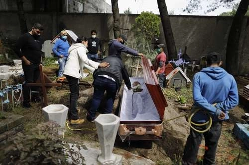 A todo sepelio –aunque la causa de muerte no sea Covid– se pide que vaya poca gente; la imagen, en el cementerio de Xilotepec en Xochimilco. Foto Ap