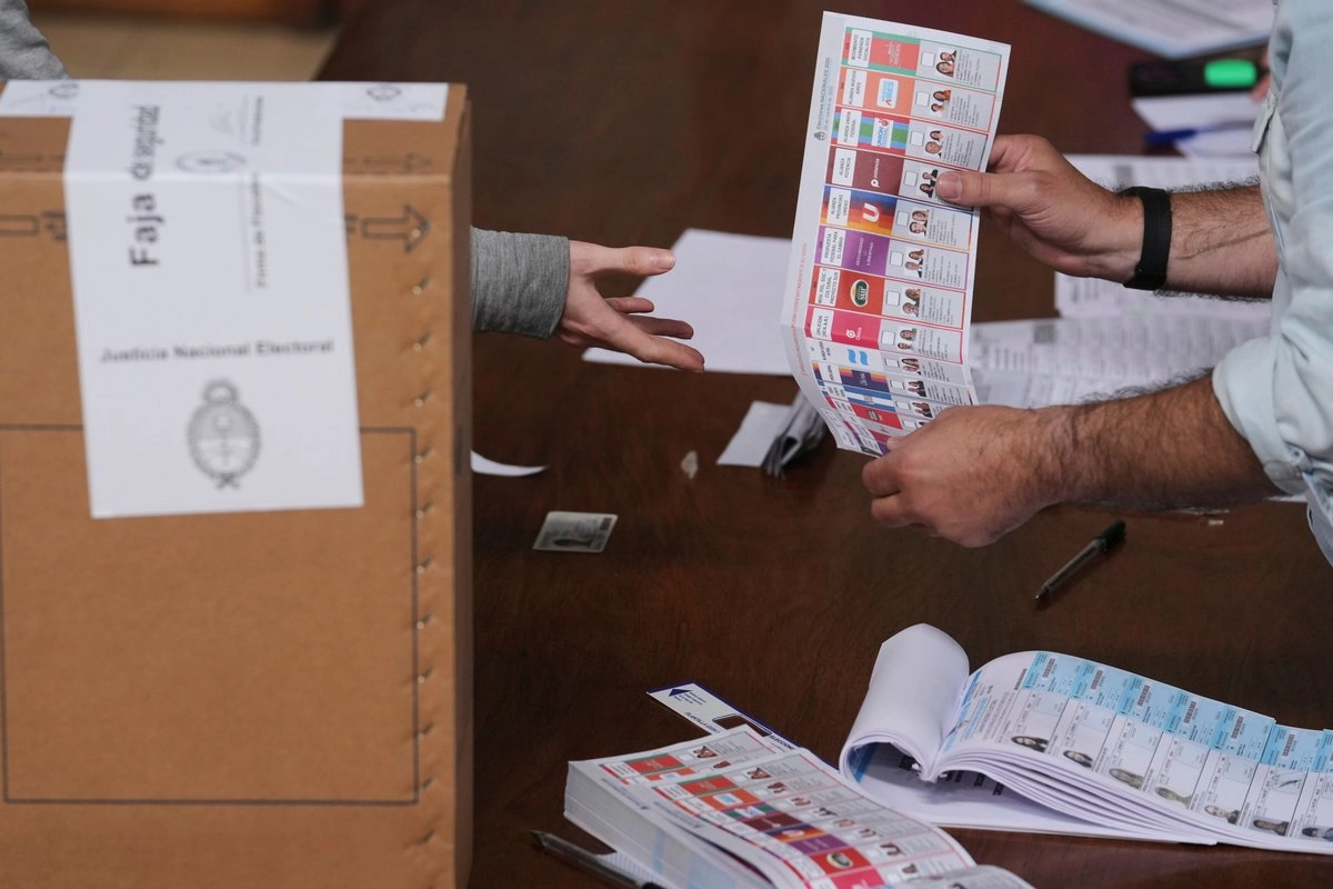 Un funcionario electoral entrega una papeleta a un votante durante las elecciones legislativas de mitad de período, en La Plata, Argentina, el domingo 26 de octubre de 2025.