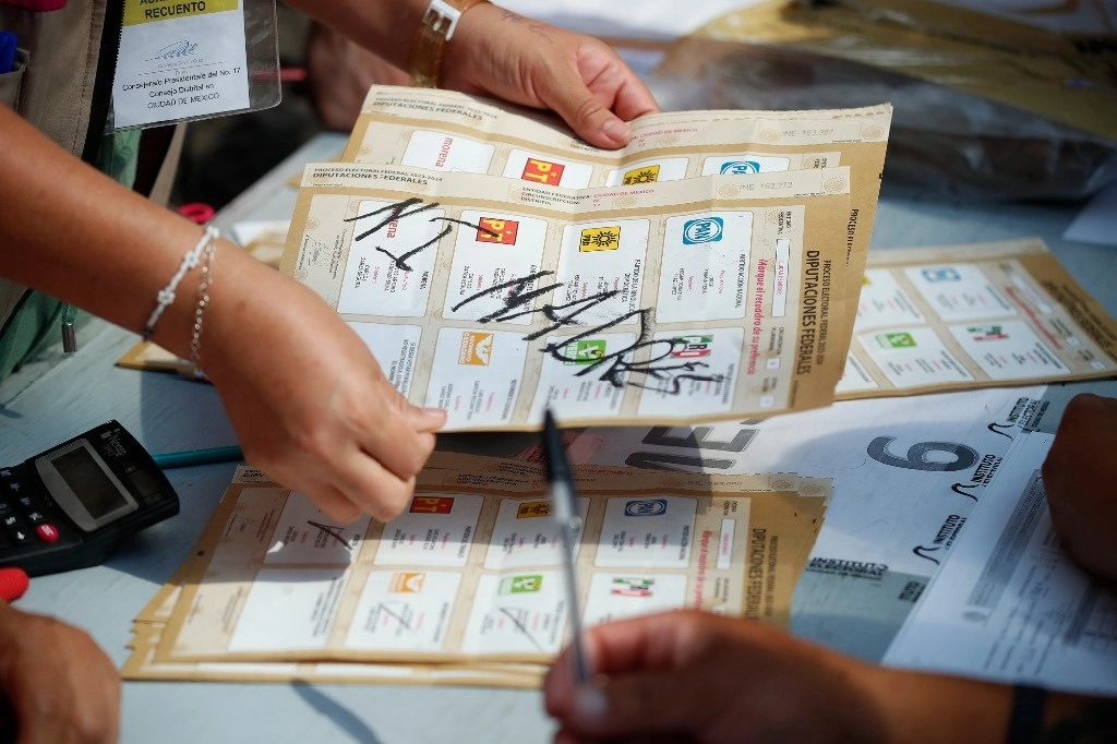 Trabajadores del INE como representantes de partidos políticos revisan las boletas con los votos en la junta distrital N 17, en la alcaldía Álvaro Obregón, en la Ciudad de México, el pasado 6 de junio. Foto Cristina Rodríguez