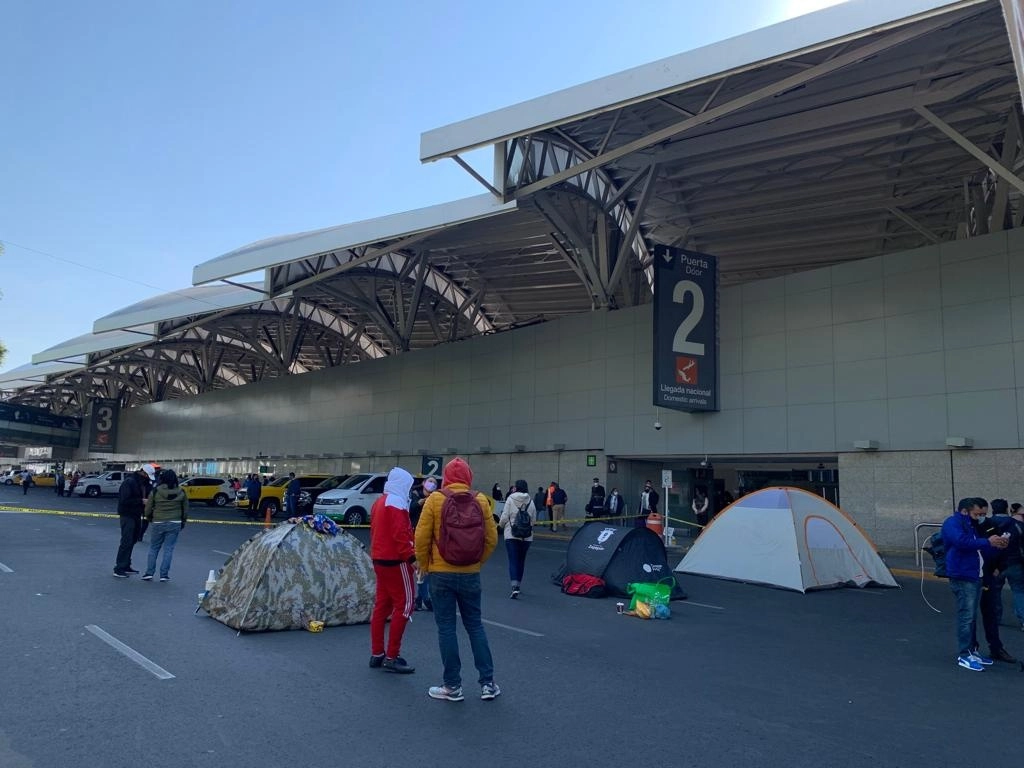 Más de 24 horas han permanecido ex oficiales de aduanas en un bloqueo en las inmediaciones de la Terminal 1 del AICM, lo que impide el paso de automovilistas. Foto Alfredo Domínguez