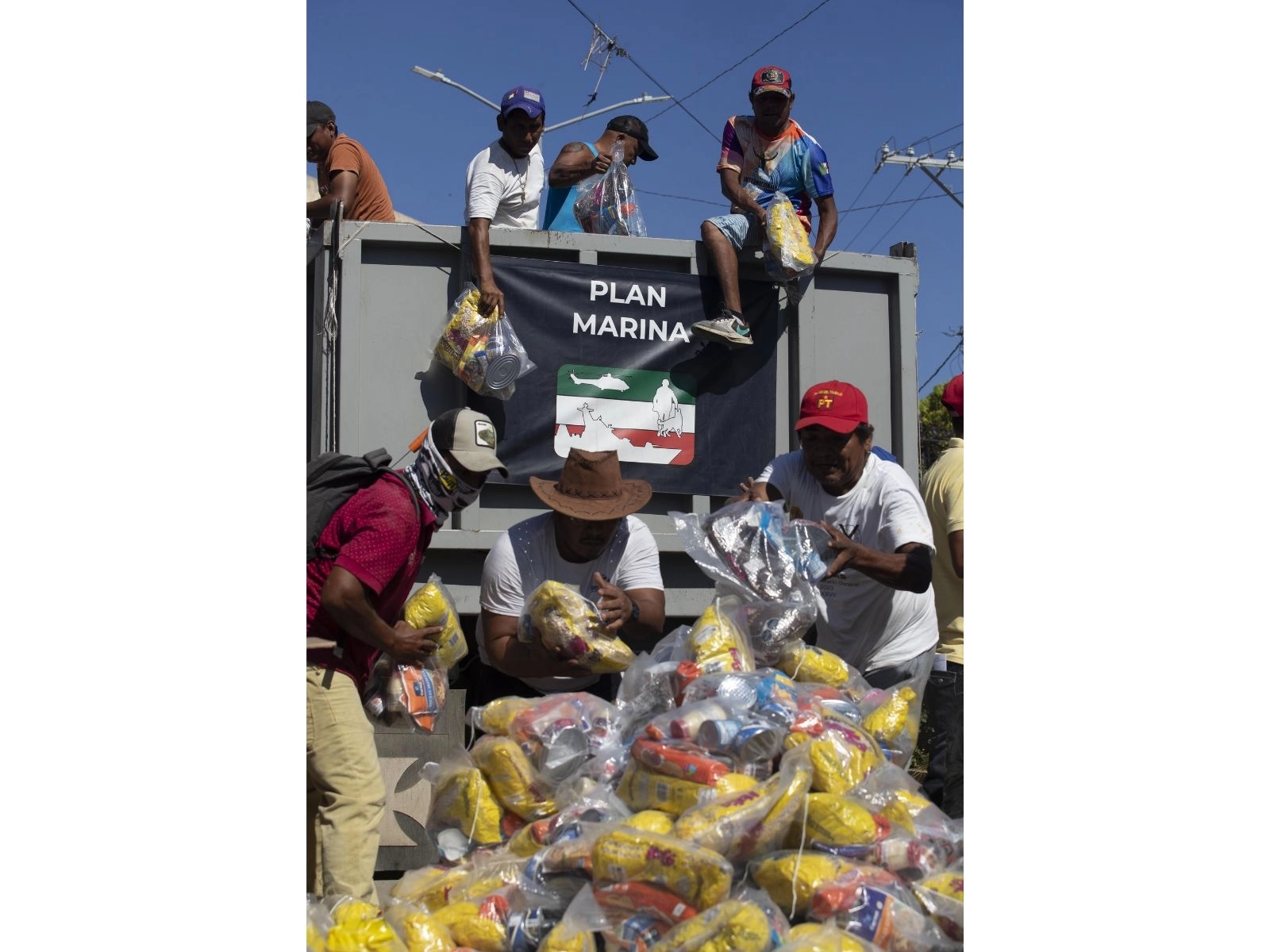 Trabajos de limpia y mantenimiento en el puerto de Acapulco tras el paso del huracán 'Otis'. , En la imagen miembros de la comunidad ayudan a bajar despensas para ser entregadas por la Marina, el 13 de noviembre de 2023. Foto Alfredo Domínguez