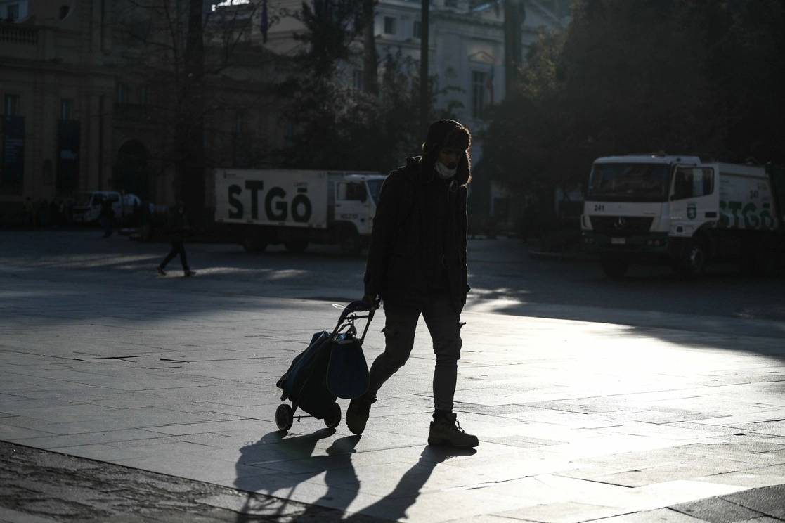 Un hombre jala un carrito mientras camina por una calle, en Santiago, Chile. Foto Xinhua /Archivo