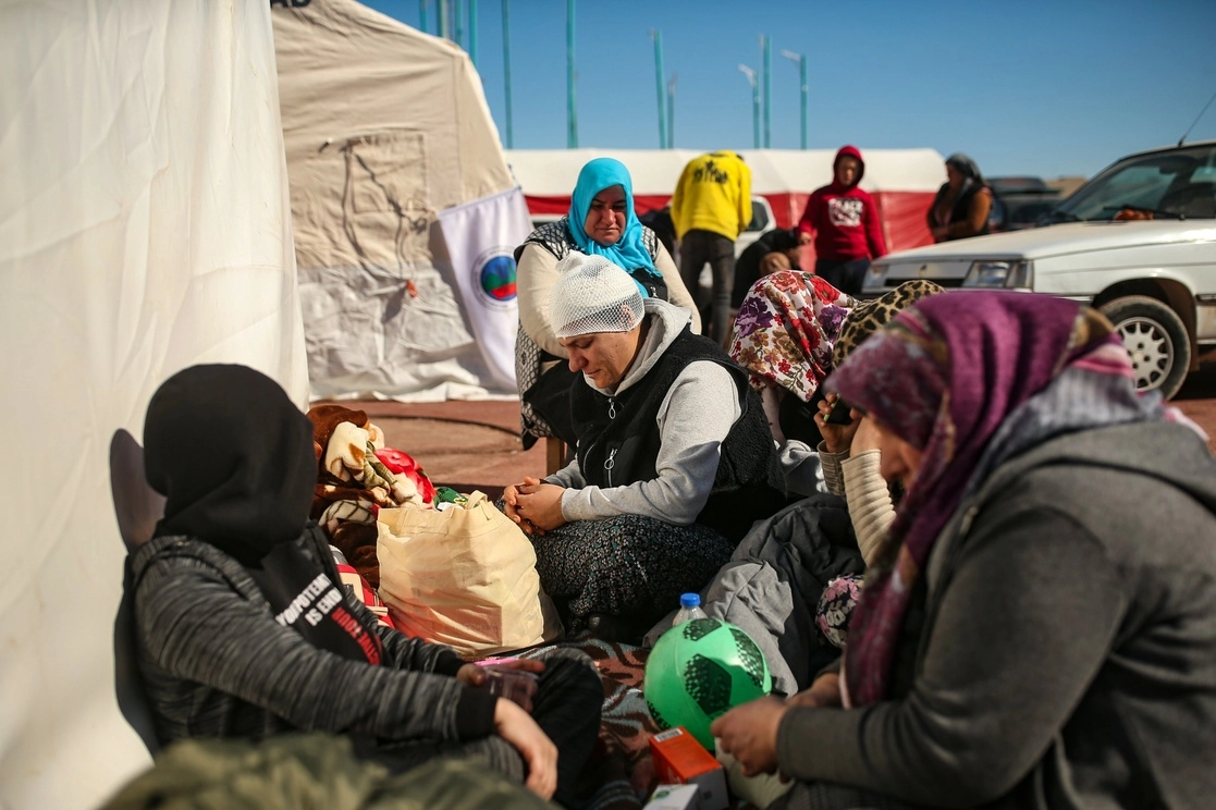 Personas sentadas junto a sus pertenencias en un campamento instalado en Adiyaman, en el sur de Turquía, el 13 de febrero de 2023. Foto Ap