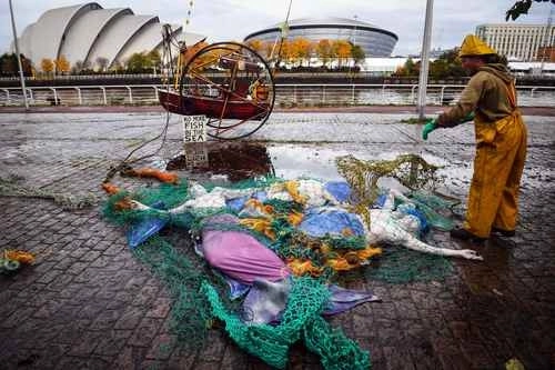 Activistas de la organización Ocean Rebellion realizaron ayer una protesta contra la pesca de arrastre cerca del Scottish Event Centre en Glasgow, Escocia, sede de la COP26, que se celebra en la ciudad a partir de hoy. Foto Ap
