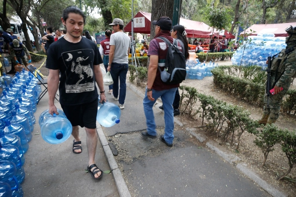Personal de la Sedena, Marina, Guardia Nacional y del gobierno capitalino entregan y rellenan garrafones de agua a vecinos de la alcaldía Benito Juárez, en imagen del 19 de abril pasado. Foto José Antonio López