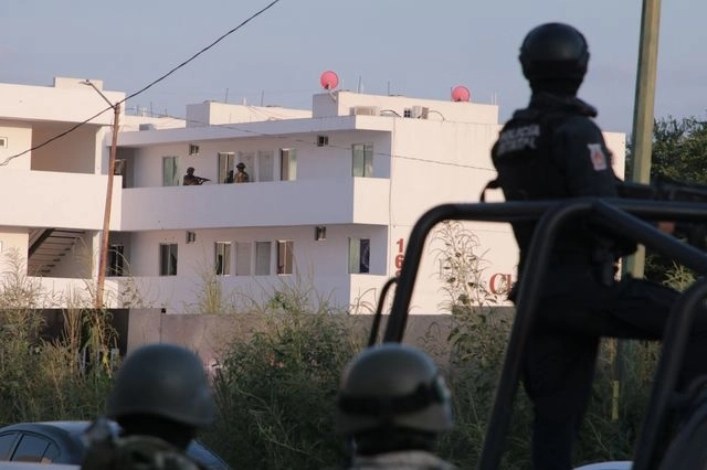 Agentes de policía ingresan a una propiedad durante un operativo en Culiacán, estado de Sinaloa. Foto Afp