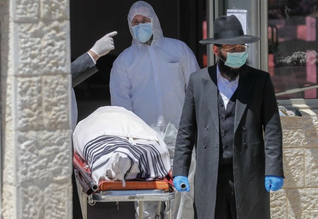 Un rabino israelí acompaña el traslado del cuerpo del ex gran rabino de los sefardíes, Eliahu Bakshi-Doron, muerto por complicaciones del coronavirus, en Jerusalén. Foto Afp 