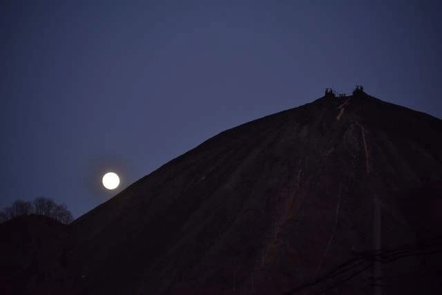La Luna se erige detrás de una montaña, vista desde Pekín, China. Foto Afp 