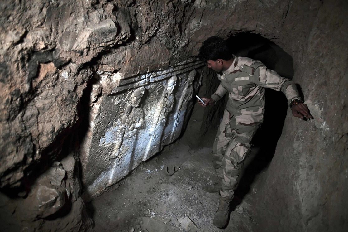 Militar iraquí inspecciona hallazgos arqueológicos en una excavación realizada por el Estado Islámico en Mosul, ciudad saqueada entre 2014 y 2017 por los yihadistas. Foto Afp