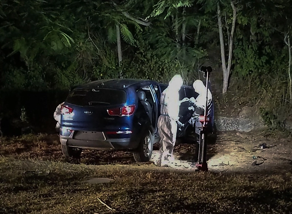 Expertos revisando el automóvil donde la difunta alcaldesa de San Vicente Brigitte García fue encontrada muerta a tiros el 24 de marzo de 2024 en San Vicente, Manabí, Ecuador. Foto Afp