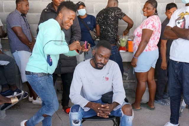 Un migrante de Haití recibe un corte de cabello de otro migrante dentro del albergue Senda de Vida 2 en Reynosa, Tamaulipas. Foto Ap
