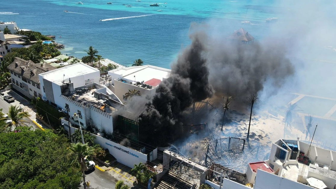 Bomberos intentan controlar el incendio en el delfinario Dolphin Discovery,en Isla Mujeres. Foto La Jornada