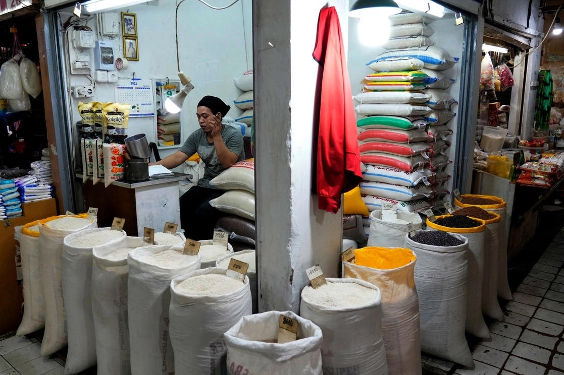 Un vendedor espera a los clientes en su puesto de arroz y otros granos en un mercado en Yakarta, Indonesia. Foto Afp