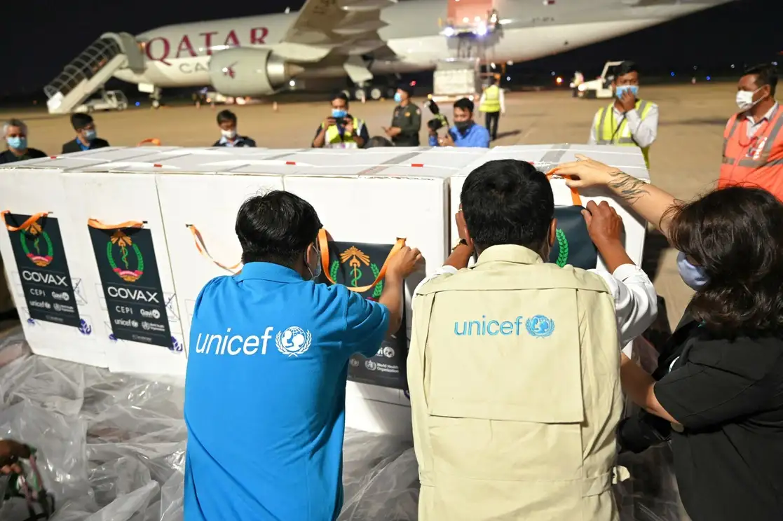 Personal de Unicef ​​coloca etiquetas sobre cajas de la vacuna contra Covid-19 durante la ceremonia de entrega de la primera asignación de la vacuna AstraZeneca de fabricación india de las instalaciones de Covax, en el Aeropuerto Internacional de Phnom Penh, Camboya, el 2 de marzo de 2021. Foto Afp