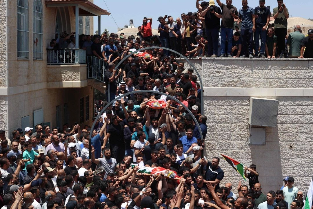 Dolientes palestinos asisten al funeral de tres personas asesinadas el día anterior en Kafr Malik, Cisjordania ocupada por Israel, el 26 de junio de 2025. Foto