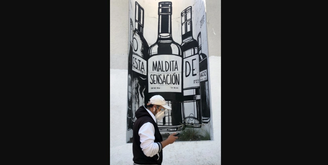 Un joven camina frente a un mural en avenida Insurgentes en la CDMX. Foto Luis Castillo