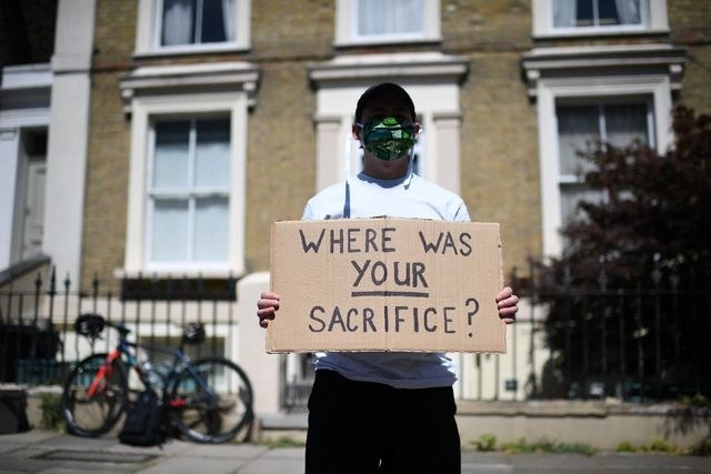 Un hombre protesta afuera del número 10 de Downing Street, en Londres, contra el asesor del primer ministro Boris Johnson, Dominic Cummings, quien desobedeció las restricciones por coronavirus. Foto Afp 
