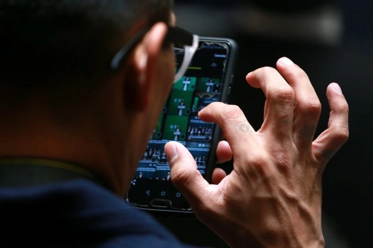Persona observa su teléfono celular en imagen de archivo. Foto 
