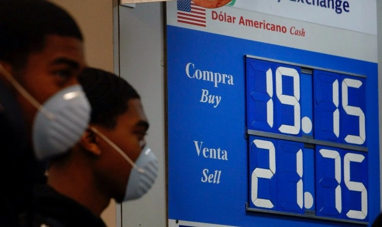 Personas con cubreboca caminan frente a una institución bancaria el pasado 16 de marzo de 2020. Foto Roberto García