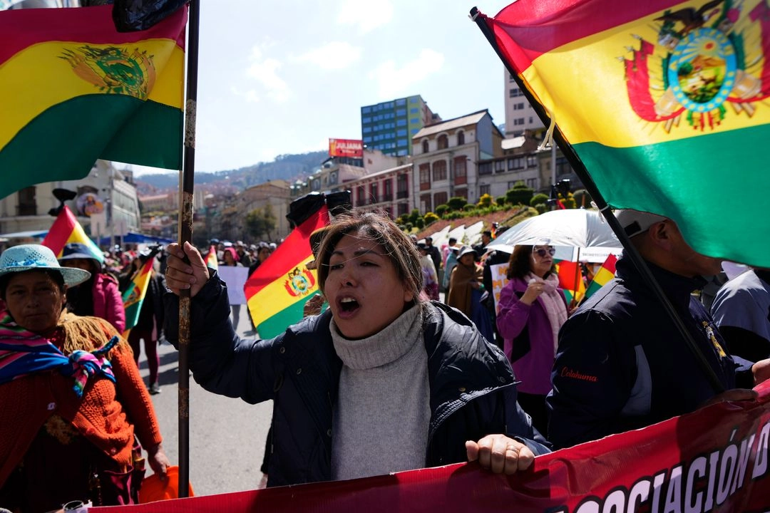 Una comerciante grita consignas contra el presidente boliviano, Luis Arce, mientras sostiene una bandera nacional durante una protesta contra la crisis económica, en La Paz, Bolivia, el miércoles 21 de mayo de 2025. Foto 