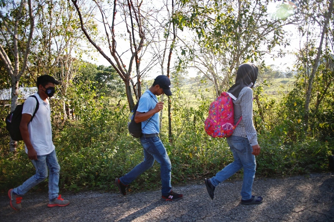 Migrantes caminan por la carretera que comunica la comunidad de Frontera Corozal con Palenque a Chiapas. Foto Víctor Camacho