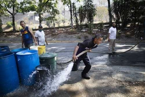 El gobierno de Caracas reparte agua potable con pipas para auxiliar a la población en el barrio de Petare, donde la escasez del líquido agrava la crisis sanitaria por la pandemia del Covid-19. Foto Ap