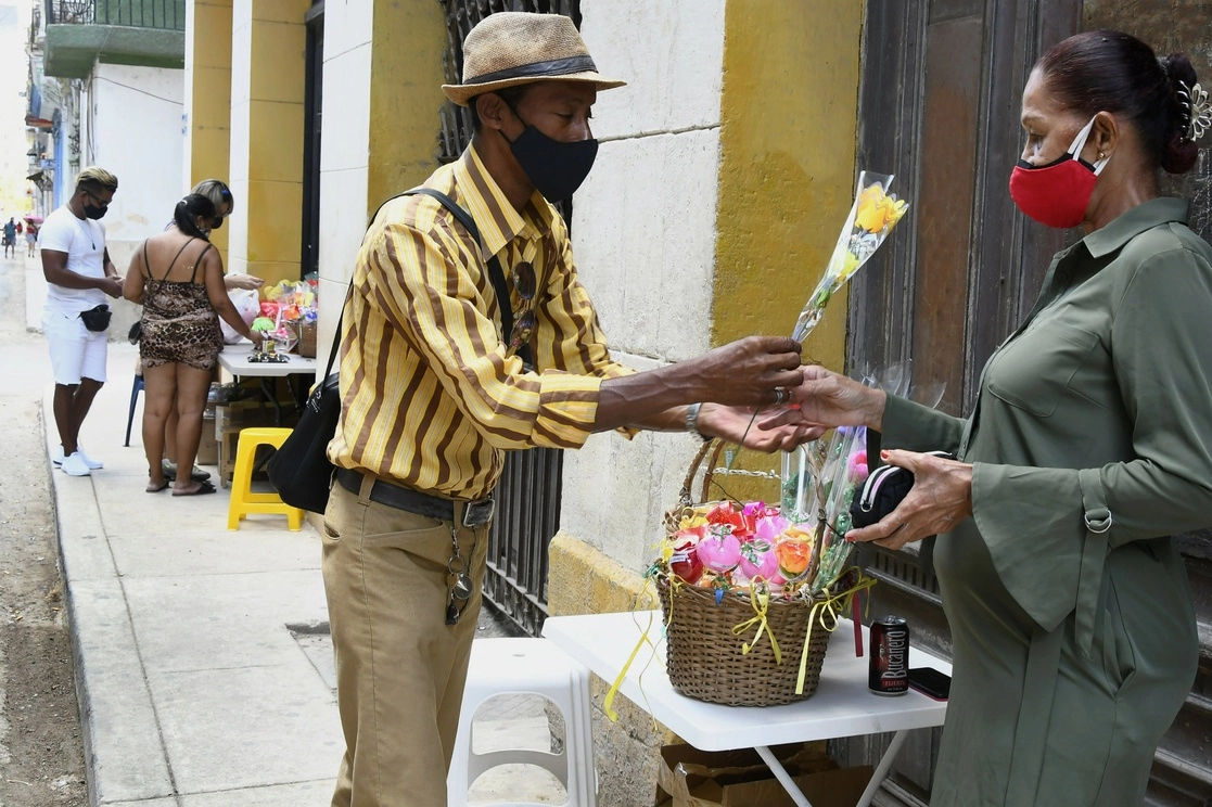 Un hombre regala una flor a una mujer durante la celebración del Día de las Madres, en La Habana. Foto Xinhua
